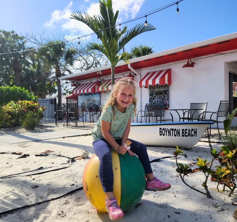 Girl in front of Boardwalk Italian Ice Cream in Boynton Beach, Florida.